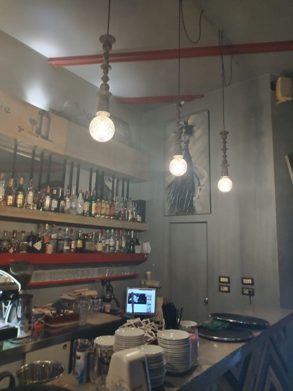 The counter of SOHO BAR Tirana with the lit back bar
