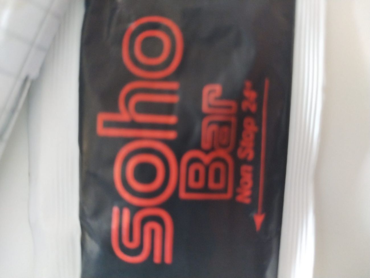 The Soho bar Non Stop 24 logo on the staff apron