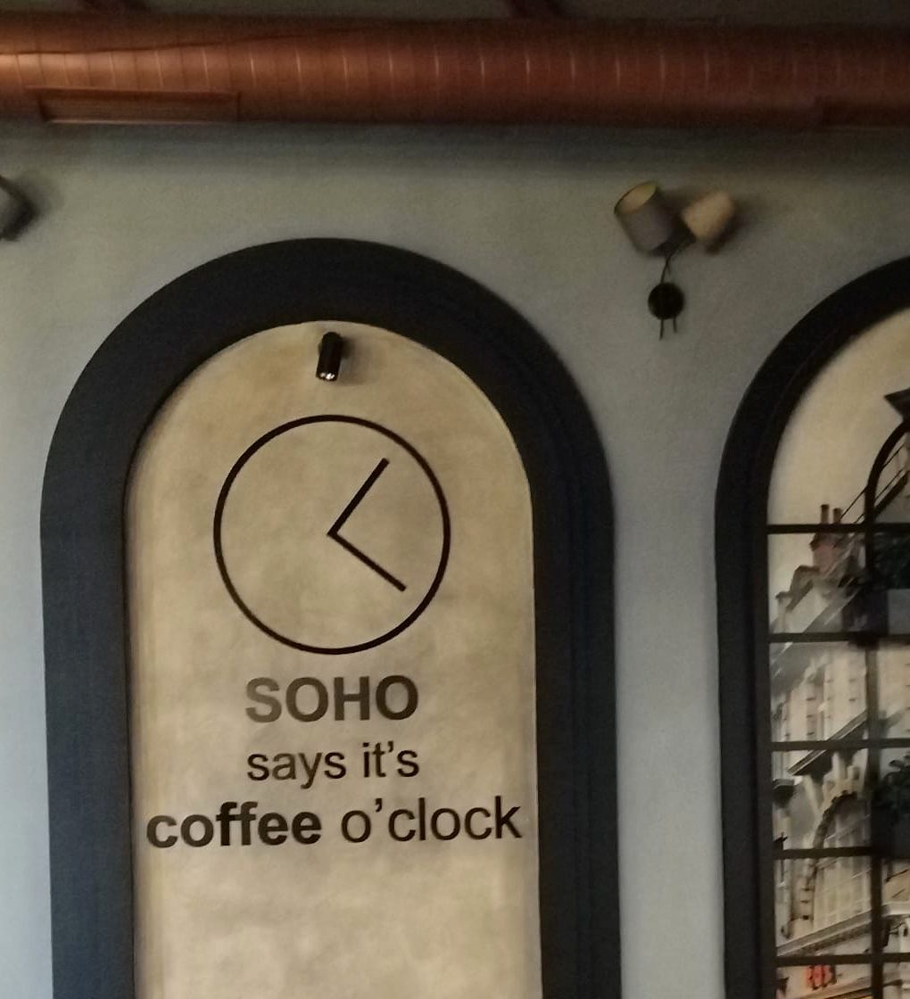 Interior arch with the wall lettering SOHO says it's coffee o'clock